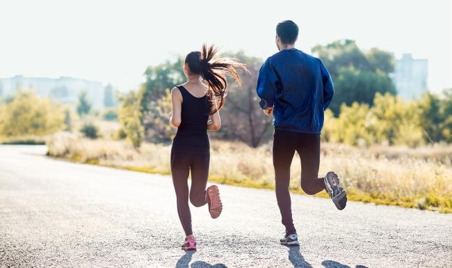 a man and woman running on a road
